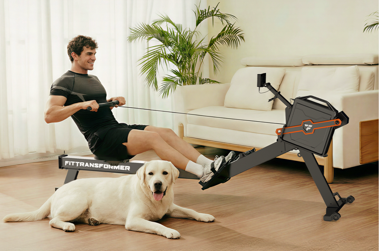 A man in workout clothes is using a black FitTransformer rowing machine in a brightly lit living room. A yellow Labrador retriever is lying on the floor in front of the machine