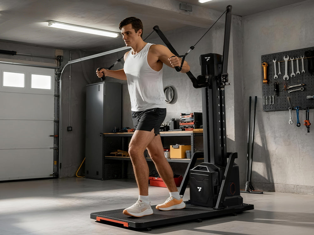 A man performing a chest fly exercise on a black smart functional trainer machine in a home garage gym